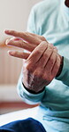 Arthritis, hands or old man in house with massage, joint pain or stiffness in finger movement. Retirement, ache and elderly person in home with rub, inflammation and muscle stretching for tendinitis.