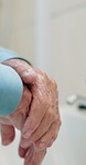 Closeup, washing and hands of old man in bathroom for hygiene, disinfection and remove bacteria. Sink, senior person and cleaning palms with soap, sanitation and morning routine at house for wellness