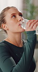 Yoga, thirsty and woman drinking water in home for hydration, exercise break and nutrition. Yogi, female person and beverage in house for liquid digestion, fitness rest and electrolytes for wellness