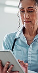 Doctor, woman and typing with tablet for healthcare, medical support or schedule for treatment. Digital tech, mature professional and report in clinic for cardiology, wellness or online telehealth