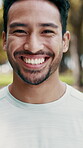 Man, face and happy in park for fitness, fresh air or wellness with positive attitude for health. Asian person, sports portrait and active with smile outdoor, wellbeing and confidence in nature