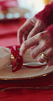 Person, hands or ribbon with plate for christmas dining decor, serving preparation or style in home. Cloth, crockery or table setter with golden ring for event catering, dinner service or hospitality