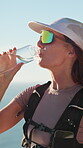 Nature, water and woman thinking on hiking break to relax, rest and ocean view with thirst. Female person, fitness and trekking outdoor with drink, sunglasses and bottle for exercise and health