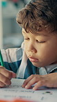 Writing, learning and kid in classroom at school with education for test, assignment or quiz. Scholarship, growth and boy student with activity for development, studying or knowledge in lesson.