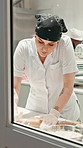 Woman, pastry chef or rolling with dough in bakery kitchen for bread, dessert or production. Female person, culinary artist or baker kneading flour for preparation, catering or hospitality in factory