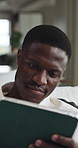 Smile, tablet and black man on sofa in home with communication, social media or reading blog. Digital technology, relax and African male person in living room for texting on app for contact in house.