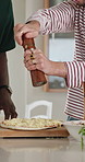Cooking, pepper and men with pizza in kitchen for dinner, lunch and meal prep together. Home, spice and hands of friends with ingredients for nutrition, wellness or help with supper at social hangout