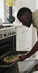 Oven, pizza and black man in home with cooking for dinner, food or meal preparation in kitchen. Culinary, ingredients and African male person with tray for baking supper with chef skills in house.