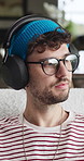 Audio, headphones and man in home, thinking and listening to music, calm and sound. Apartment, reflection and person in lounge, live streaming for podcast and digital app for radio and subscription