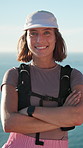 Arms crossed, face and hiking with woman outdoor at ocean for adventure, hobby or travel. Backpacking, confident and smile of hiker person in nature to explore for discovery, fitness or trekking
