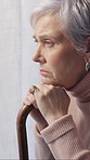 Thinking, walking stick and senior woman in home, anxiety and mourning for grief, sad and nostalgia. Reflection, stress and person with depression, mental health or retirement with cane and alzheimer
