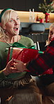 Christmas, present and child with grandmother in home for tradition, festive season and celebration. December, family and girl with grandma with surprise, excited and giving gift for xmas holiday