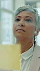 Glass wall, idea and business woman in office for financial strategy, agenda and writing. Sticky note, planning or mature consultant thinking of investment, project management or problem solving
