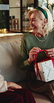 Christmas, gift and women in home, excited and celebration for festive season, parent and talking, Smile, family and mature mother in lounge, present for Xmas or happiness for tradition or discussion