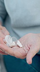 Pills, medication and hands of woman in home with treatment, vitamins or sickness in living room. Medicine, pharmaceutical and person with tablets for illness, supplements or prescription capsules.