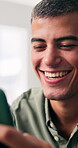Typing, laugh and man in home with phone, funny chat and post update on social media. Happy, digital gif and male person in house with tech, online communication or meme reaction in text message.