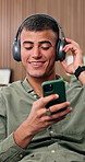Headphones, smartphone and man in home, rhythm and listening to music, connection and smile. Dancing, energy and person in lounge, cellphone and streaming for radio, audio and digital app for sound