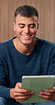 Man, tablet and relax with laugh on sofa for funny video, meme or post on web in living room. Person, happy and tech with streaming subscription, application or social media on couch at apartment