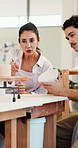 Pottery, people and teacher in workshop for help, feedback or learning process with tips. Ceramic class, creative studio and instructor with mug for art design, teaching technique and handcraft guide