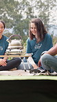 Summer camp, volunteer and people with kettle in nature for conversation, laughing and bonding. Forest, morning and counselor with friends for outdoor program, youth facility and camping adventure