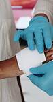 Bandage, wound and hands with people in hospital for injury, paramedic treatment and healthcare. Medical recovery, first responder and cotton with person in agency for help, bruise and emergency