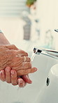Elderly, person or washing hands with soap in bathroom sink for hygiene, disinfection or cleaning. Closeup, senior or rinsing with disinfectant for skincare, bacteria or germ and dirt removal in home