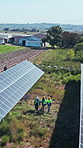 Drone, solar panel and people with teamwork for renewable energy, walking and power generator. Industry group, photovoltaic grid and employees with inspection for maintenance, safety or collaboration