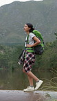 Woods, hiking and woman on river adventure, sightseeing or backpacker on peaceful holiday in nature. Backpacking, outdoor and person on vacation, exploration and walking on weekend break in forest
