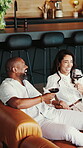 Toast, talking or happy couple with wine on sofa, funny conversation or laugh for anniversary bonding. Cheers, alcohol or mature people with joke for valentines day,  interracial relationship or home