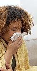 Sick, tissue and woman blowing nose on sofa in home with medicine for cold, flu or sinus infection. Illness, virus and female person with toilet paper for allergies or hayfever in living room.