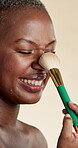 Nose, makeup brush and beauty with black woman in studio for self care, glow and foundation. Cosmetics, highlighter shine and cosmetology with person on white background for eyeshadow and blush