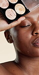 Product, makeup and beauty with black woman in studio for self care, glow and foundation. Cosmetics, highlighter shine and cosmetology with person on white background for eyeshadow and blush