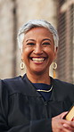 Happy woman, judge and books with face in city with confidence, pride and legal career in street. Mature person, magistrate and smile for portrait in town with law, literature and justice in Mexico