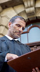 Judge, man and documents in city for court case, review and notes in street with legal career. Mature person, magistrate and low angle with folder, legislation or justice with insight for report