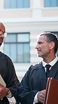 Lawyer, discussion and men in city, feedback and advice for compliance review. Judge, outdoor and people in street, legal case planning and criminal investigation with teamwork, portfolio and support