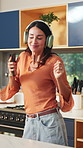Happy woman, headphones and dancing with phone in kitchen with sound, streaming and song in home. Person, smile and rhythm with mobile app, audio and listen to music with subscription at apartment