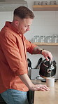 Morning, kitchen and man with kettle for coffee, caffeine and warm drink to start day in home. Apartment, pouring and person with hot water to prepare beverage for calm, wellness and breakfast