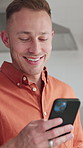 Reading, online and happy man with phone in kitchen, laughing and funny message on social media app. Texting, home and person with mobile for communication, humor and chat with tech on weekend break