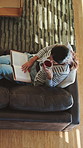 Drink, reading and above of woman on sofa with book for literature, hobby and relax on weekend. Home, rest and person on couch with beverage and story, novel and chapter for calm, peaceful or me time
