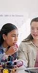 Girls, robotics and conversation in school for students, learning or future development. People, laptop and education with electronics, transportation or machine for knowledge or engineering project