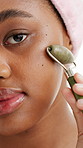 Jade roller, skincare and face of black woman in studio for wellness, beauty and facial treatment. Dermatology, portrait and person with tools for anti aging, massage and health on white background
