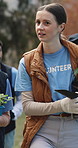 Volunteer, woman and team in park with plants, sustainability and discussion for eco friendly project. Charity, people walk and talk outdoor with tree for community garden, collaboration or planning.