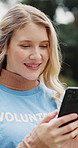 Happy woman, volunteer and typing with phone in nature for social media post or outreach. Female person, activist or NGO with smile on smartphone for charity, community service or earth day in park