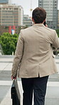 Back, businessman and walk in city with phone call, briefcase and feedback for real estate appointment. Realtor, person and outdoor in urban town with tech, contact and journey to property listing.