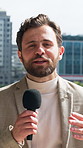 Face, reporter and man with microphone in city, explain story and live coverage for breaking news update. Portrait, talking and anchor with tech for broadcast, current events segment and pov in town