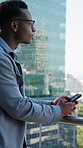 Black man, thinking or realtor with phone on balcony for business or building investment in city. Businessman, real estate and contemplating with smartphone for corporate property or urban settlement
