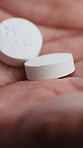 Person, hands and pills with medication for cure, prescription or medical symptoms in clinic. Closeup, tablets or healthcare with antibiotic, paracetamol or health treatment for pharmaceuticals
