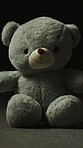 Teddy bear, loss and toy on studio floor for adoption fail, neglect and abandoned on dark background. Isolation, lost hope and stuffed animal with loneliness, unwanted and forgotten on ground