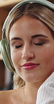 Headphones, dance and woman on sofa in home listening to music, podcast or radio on app. Happy, audio tech and female person in living room with streaming playlist or album in apartment on weekend.