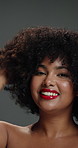 Face, woman and smile with haircare in studio with curly texture, natural growth and maintenance. Female person, afro hairstyle and treatment for hydration glow, grooming benefits and gray background